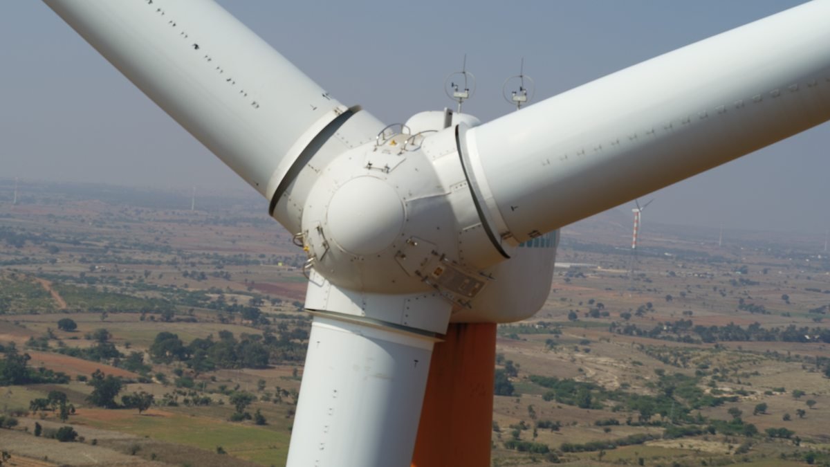 Aerial view looking down on a wind turbine hub and the roots of three blades